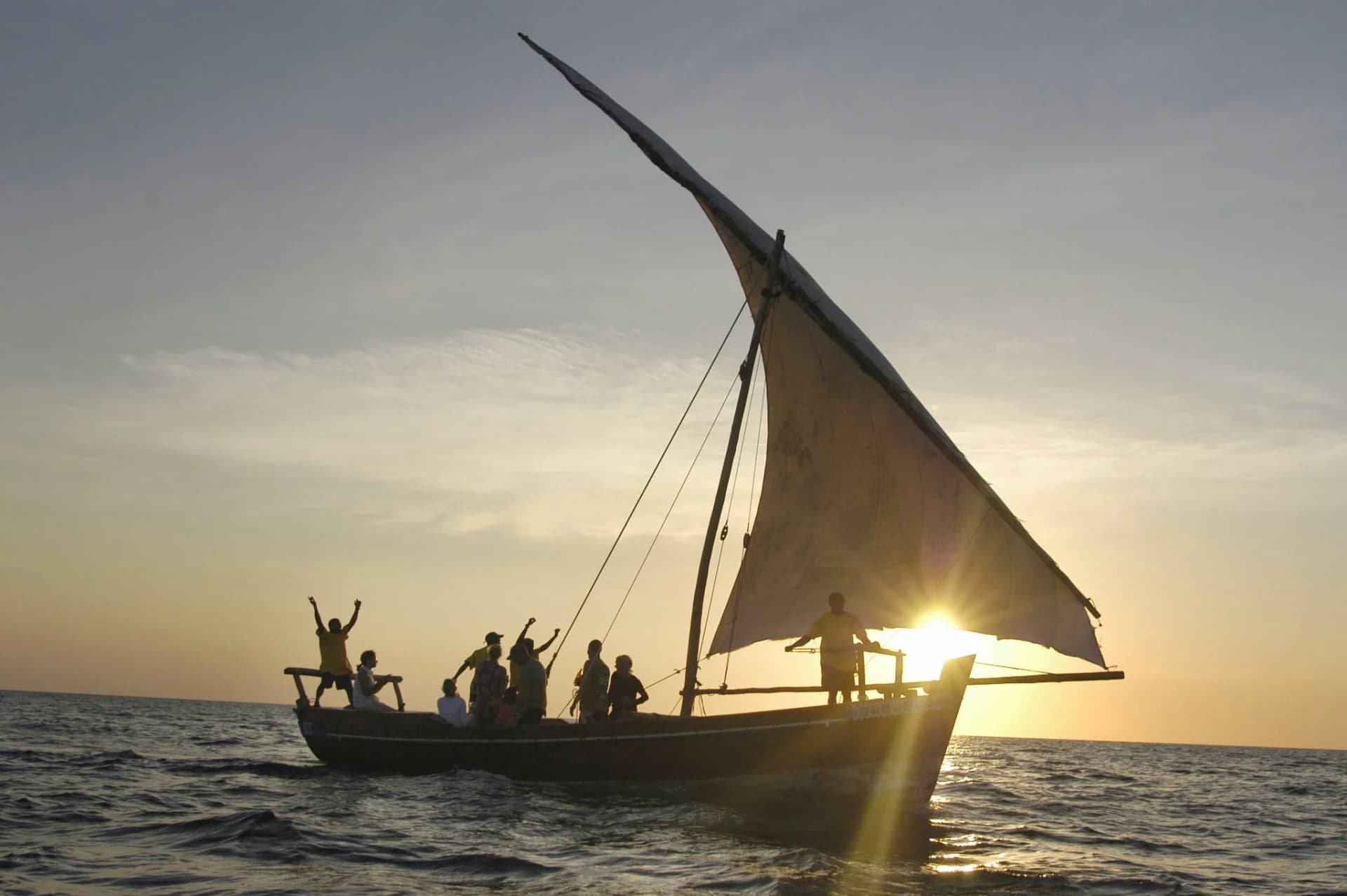 Un dhow tradizionale che naviga al tramonto al largo della costa di Zanzibar